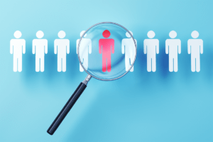 Magnifying glass over symbols of people to represent searching for locums providers.