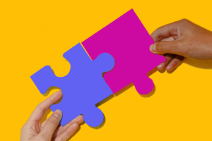 Two hands putting together puzzle pieces to represent proper Healthcare MSP implementation