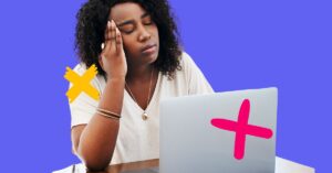 Woman holding her head and looking at a laptop to signify healthcare worker burnout.