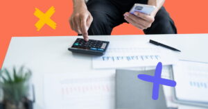 Person at a desk with a calculator to represent cost containment in healthcare staffing.